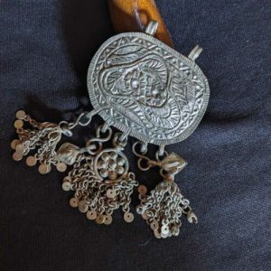 Close-up of Kashmiri jewelry showcasing intricate filigree work with delicate patterns and embedded gemstones.